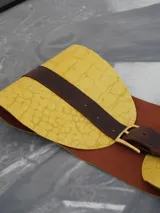 Cinturón de cuero marrón oscuro con una sección ancha en amarillo texturizado, que se ajusta a la cintura.