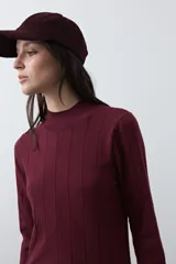 Polera de tejido de punto con cuello alto y diseño de rayas verticales sutiles. Presenta un ajuste al cuerpo y mangas largas.