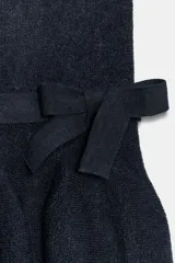 Top de punto sin mangas con escote recto, diseño ajustado al cuerpo y bajo con volado peplum. Presenta un detalle de lazo decorativo en la cintura.