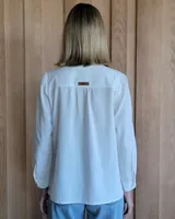 Camisa de jean azul con cuello alto con volados y volados en el frente.