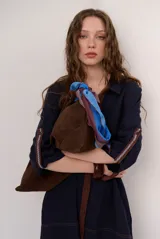 Vestido chemise azul marino con costuras a contratono en color marrón. Presenta cuello camisero, botones frontales y mangas 3/4 con detalles bordados en los puños.