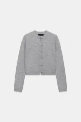 Chaqueta de punto gris con cuello redondo, manga larga y cierre frontal mediante alamares.