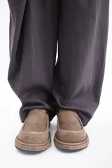 Zuecos de cuero vacuno en color beige, con diseño de punta redondeada y suela plana de goma.