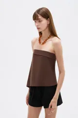 Top strapless de viscosa en color marrón, con diseño asimétrico y corte holgado.