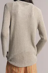 Chaqueta de punto color beige con escote en V, manga larga y cierre frontal con botones dorados.