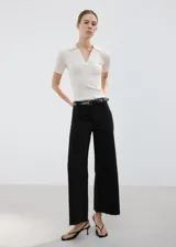 Pantalón de jean negro de corte recto y tiro alto, con diseño de pierna ancha y terminaciones deshilachadas en el ruedo.