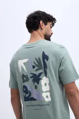 Remera verde militar de corte regular, con estampa abstracta y floral en la espalda y texto descriptivo de la marca Brooksfield.