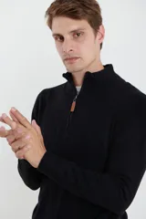 Sweater verde oliva de tejido acrílico con textura similar al cashmere, corte clásico, cuello alto con cierre metálico y tirador de cuerina ecológica.