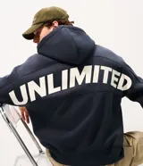 Buzo canguro masculino azul marino con capucha, medio cierre frontal y un gran estampado con la palabra "UNLIMITED" en la espalda.