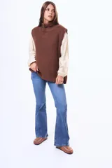 Chaleco tejido de punto en color marrón, con cuello alto y diseño sin mangas de corte holgado.