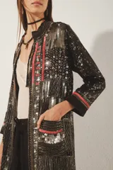 Saco largo abierto de corte recto, con mangas largas y cuello redondo. Confeccionado en crepe con bordado artesanal de piedras, lentejuelas, canutillos y mostacillas, con detalles en jacquard en puños y ruedo. Incluye bolsillos delanteros y forrería interna.