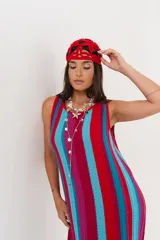 Vestido largo tejido a crochet con rayas verticales en colores fucsia, rojo y celeste.