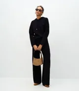 Buzo de punto con capucha y cordones ajustables con punteras metálicas. Presenta un diseño de corte regular, confeccionado en una mezcla de viscosa, poliéster y poliamida, ofreciendo una textura suave y cómoda.