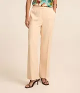 Pantalón de vestir color beige, de corte recto, con cintura alta y cierre tradicional con cremallera.