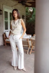 Pantalón de tiro alto con pierna levemente acampanada, confeccionado en lino. Presenta diseño clásico con pinzas delanteras y cierre frontal.