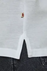 Chomba de piqué color blanco, de corte slim fit, manga corta y cuello camisero con cierre frontal de botones.