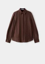 Camisa de satén color marrón chocolate, con cuello camisero, cierre frontal de botones ocultos y mangas largas con puños abotonados. Presenta un diseño recto adornado con pequeños detalles de strass brillantes distribuidos por toda la prenda.