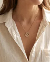Collar de acero con baño dorado y dije en forma de trébol calado con circonias engarzadas.