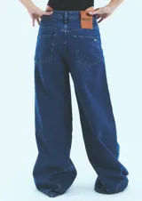Jean de corte oversize confeccionado en denim de algodón con lavado azul clásico. Presenta tiro medio-bajo, cierre frontal con botón y bolsillos laterales.