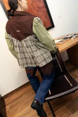 Jean de corte recto y tiro medio, confeccionado en denim celeste con inserciones de cuero marrón en las piernas que simulan chaparreras.
