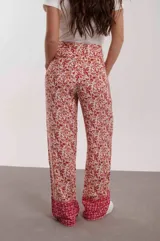 Pantalón de mujer con estampado floral en tonos rosa y rojo, de corte palazzo y cintura alta.