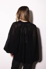 Camisa holgada de popelina de algodón con diseño de rayas verticales en tonos rosado, blanco y negro. Presenta cuello alto con volado, hombros caídos y mangas anchas abullonadas con puños ajustados. Cierre frontal con botones.