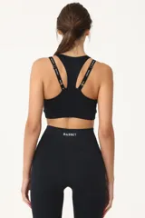 Top deportivo negro con espalda cruzada, elástico inferior y tiras regulables con logo Basset.