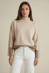Polera de punto con diseño color block en tonos beige y marrón, de corte oversize, cuello alto y mangas largas con puños acanalados.