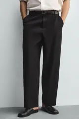 Pantalón de corte balloon fit confeccionado en una mezcla de lyocell y algodón. Presenta cierre frontal con cremallera y botón, bolsillos laterales y bolsillos traseros de vivo.