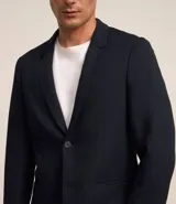 Blazer azul marino de tejido texturizado, con cuello solapa, abotonado delantero, mangas largas y bolsillos. Corte clásico.