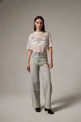 Pantalón jean de tiro alto y corte recto, confeccionado en denim celeste con aplicación de strass en toda la parte frontal.