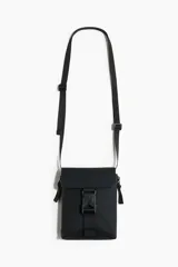 Bandolera negra de diseño rectangular, con solapa frontal y cierre de hebilla plástica. Cuenta con correa ajustable y tiras laterales decorativas.