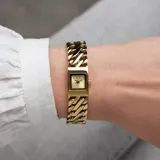 Reloj Michael Kors modelo Darrington con caja cuadrada y malla de eslabones tipo cadena en acero dorado. Esfera minimalista a tono con logo de la marca.