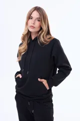 Buzo tipo canguro de felpa color marrón, con capucha ajustable mediante cordones y bolsillo frontal tipo canguro.