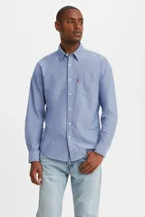 Camisa celeste de manga larga, corte clásico, con cuello abotonado, bolsillo en el pecho y logo de la marca en rojo.