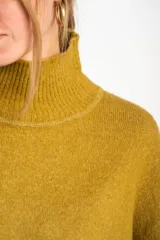 Sweater celeste de punto con cuello alto y mangas largas.