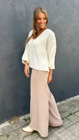Sobrecamisa de viscosa con detalles de lúrex, color marfil, con escote en V, cierre frontal abotonado y mangas abullonadas.