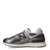 Championes urbanos New Balance modelo 574, color gris metalizado con detalles en color natural. Presentan el logo N característico en los laterales, cordones al tono y entresuela con tecnología ENCAP para mayor amortiguación.