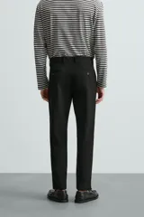 Pantalón chino de corte slim fit, confeccionado en tejido elástico. Presenta bolsillos frontales, bolsillos traseros de vivo con botón y cierre frontal con cremallera y botón.