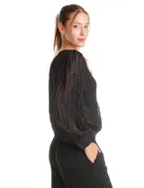 Blusa negra de gasa translúcida con diseño de líneas verticales texturizadas y sutiles aplicaciones de lentejuelas. Presenta cuello a la base, cierre frontal con botones, mangas largas estilo balloon con puños abotonados y ruedo elastizado.