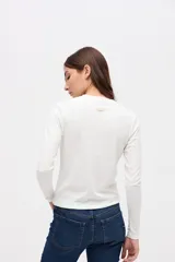 Remera de manga larga con cuello redondo, confeccionada en tejido rib con textura acanalada y calce ajustado al cuerpo.