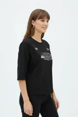 Remera negra de manga corta, cuello redondo y diseño holgado, con estampado frontal en color blanco con la inscripción "Race Vibes".