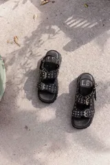 Sandalias de cuero marrón con plataforma de goma negra y hebillas metálicas.