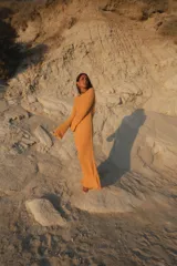 Vestido largo de tejido de punto negro con escote en la espalda y mangas largas.