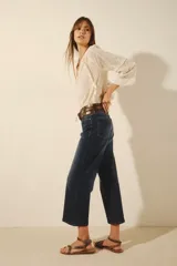 Jean de corte oxford tiro alto, con pierna que se ensancha desde la cadera y largo midi a la pantorrilla. Confeccionado en denim azul con elastano, presenta un lavado localizado y bigotes.