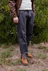 Bombacha de campo de corte sastrero con pinzas delanteras, color gris oscuro. Presenta una silueta moderna con botamangas con abertura y ajuste, y detalles en cuero.