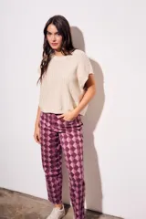 Chaleco de punto con textura acanalada y acabado brillante, de corte holgado, cuello redondo y mangas cortas estilo sisa.