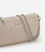 Cartera femenina modelo baguette, color beige, con acabado brillante y asas desmontables. Confeccionada en poliuretano, tiene una correa de cadena plateada y un logo metálico en el frente.