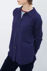 Cardigan de punto color beige, con cuello camisero, cierre frontal de botones y bolsillo aplicado en el pecho. Presenta mangas largas con puños acanalados y un corte recto y holgado.