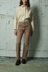 Jean de corte recto y tiro medio, color chocolate con efecto lavado. Presenta costuras visibles, bolsillos laterales y traseros, y ruedo deshilachado.